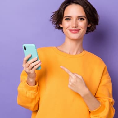 a young woman in a yellow jumper pointing at the telephone